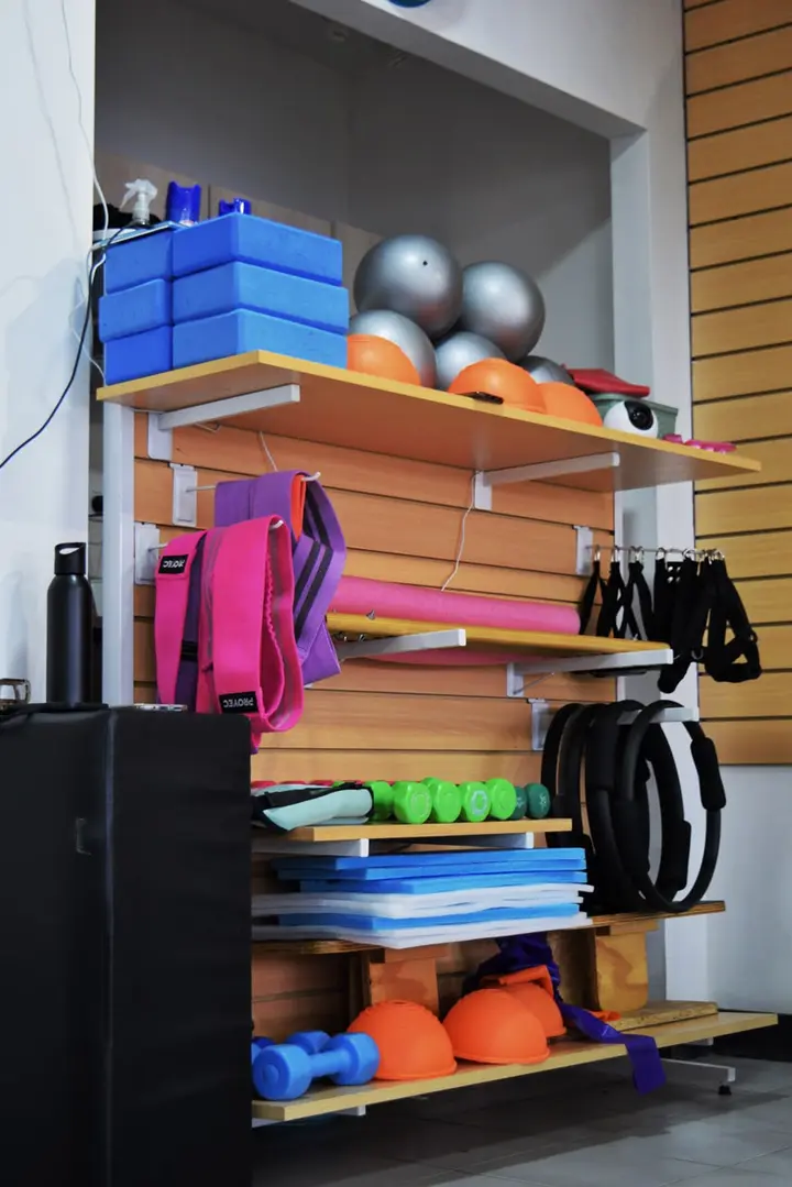 Estante con bandas, aros, bloques, colchonetas y mancuernas en Metanoia Pilates